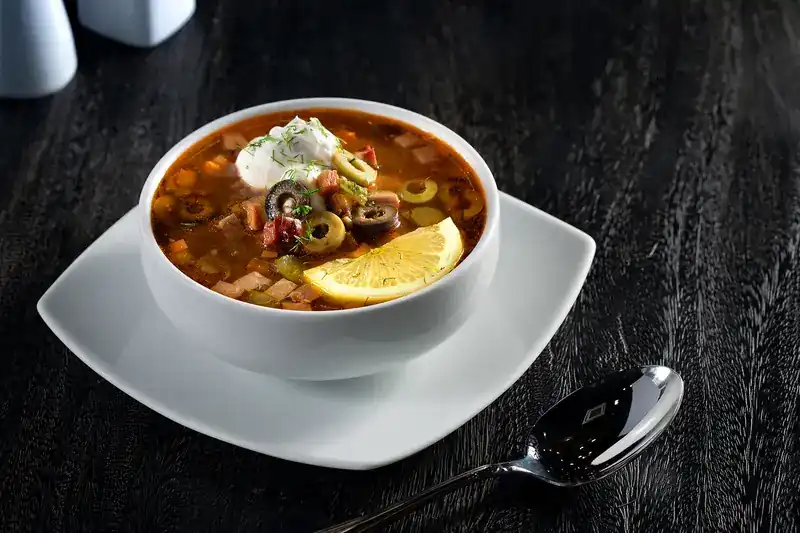 Solyanka with olives, a slice of lemon and sour cream