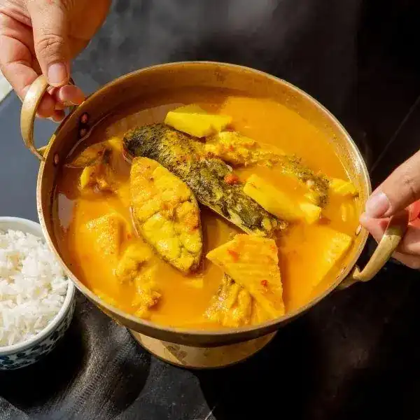 แกงส้มปลากระพง: orange curry with sea bass in a brass pot
