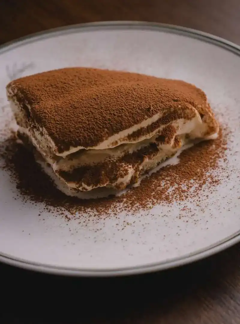 A slice of tiramisu dusted with cocoa