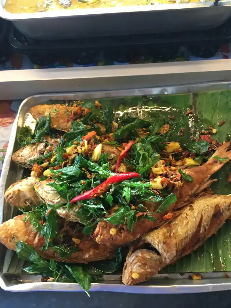 Fried fish under crisp-fried herbs and chillies