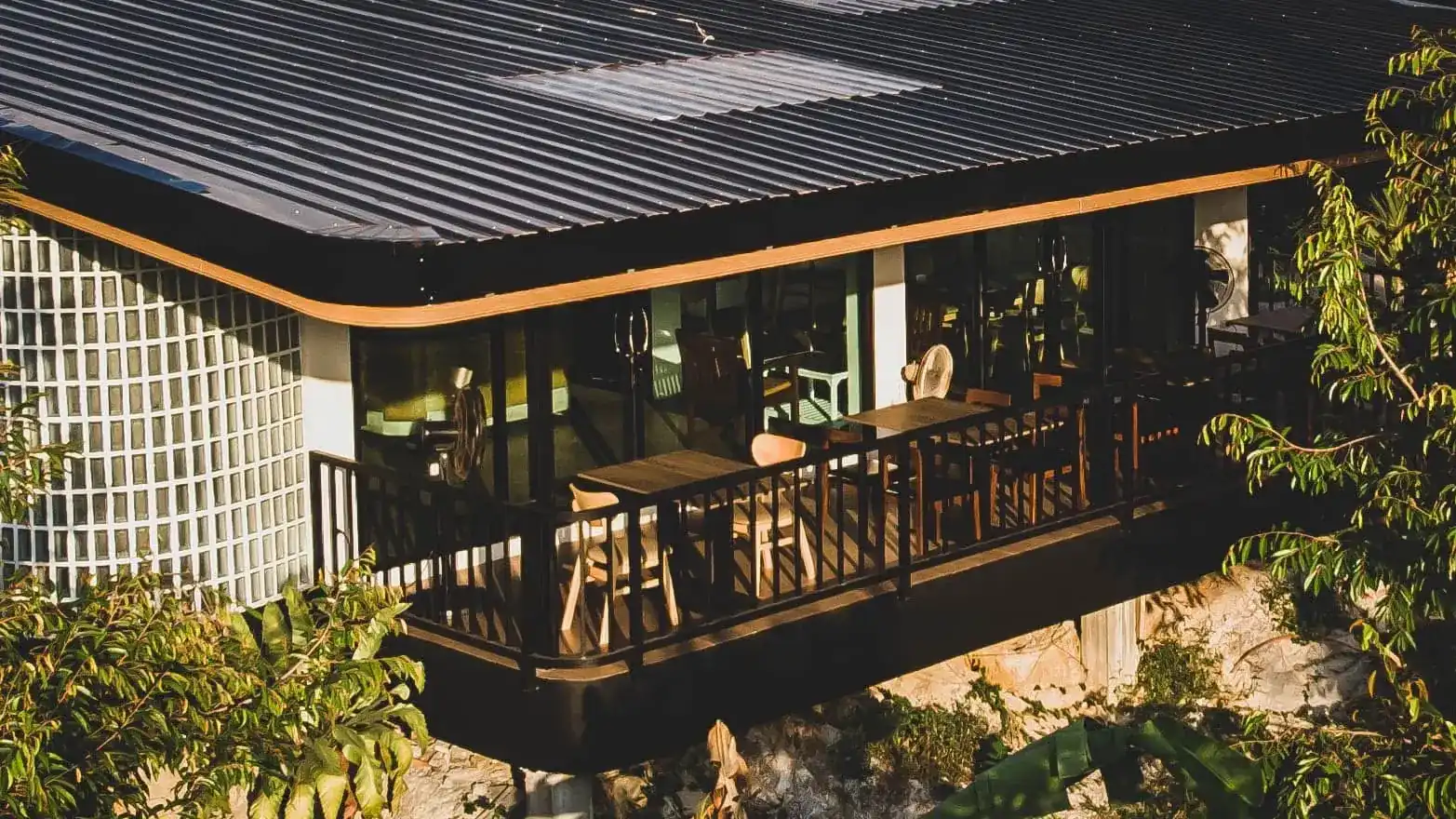 The terrace of Suanpa under its curved roof, among the trees / ระเบียงร้านสวนป๋าใต้หลังคาโค้ง ท่ามกลางต้นไม้