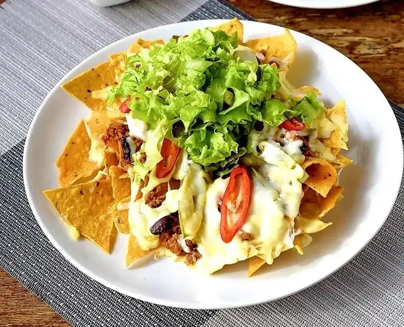 Nachos with melted cheese, chilli and fresh lettuce