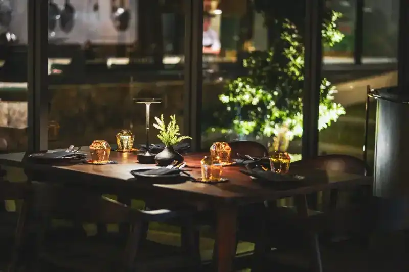 A table set for the evening by the garden windows, candles lit
