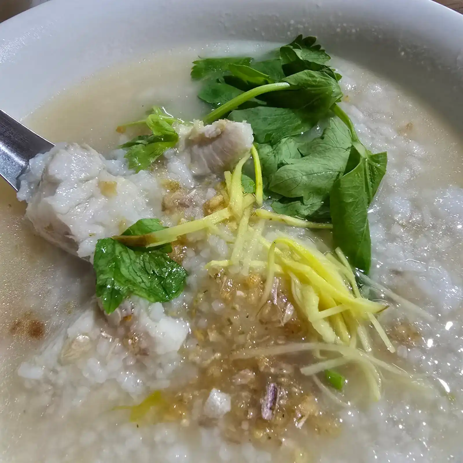 Rice porridge with fish, ginger and fresh herbs