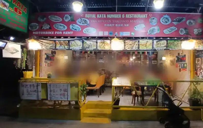 The shop front at night: a long red sign, the halal sign and the yellow rail / หน้าร้านยามค่ำ ป้ายสีแดงยาว ป้ายฮาลาล และราวสีเหลือง