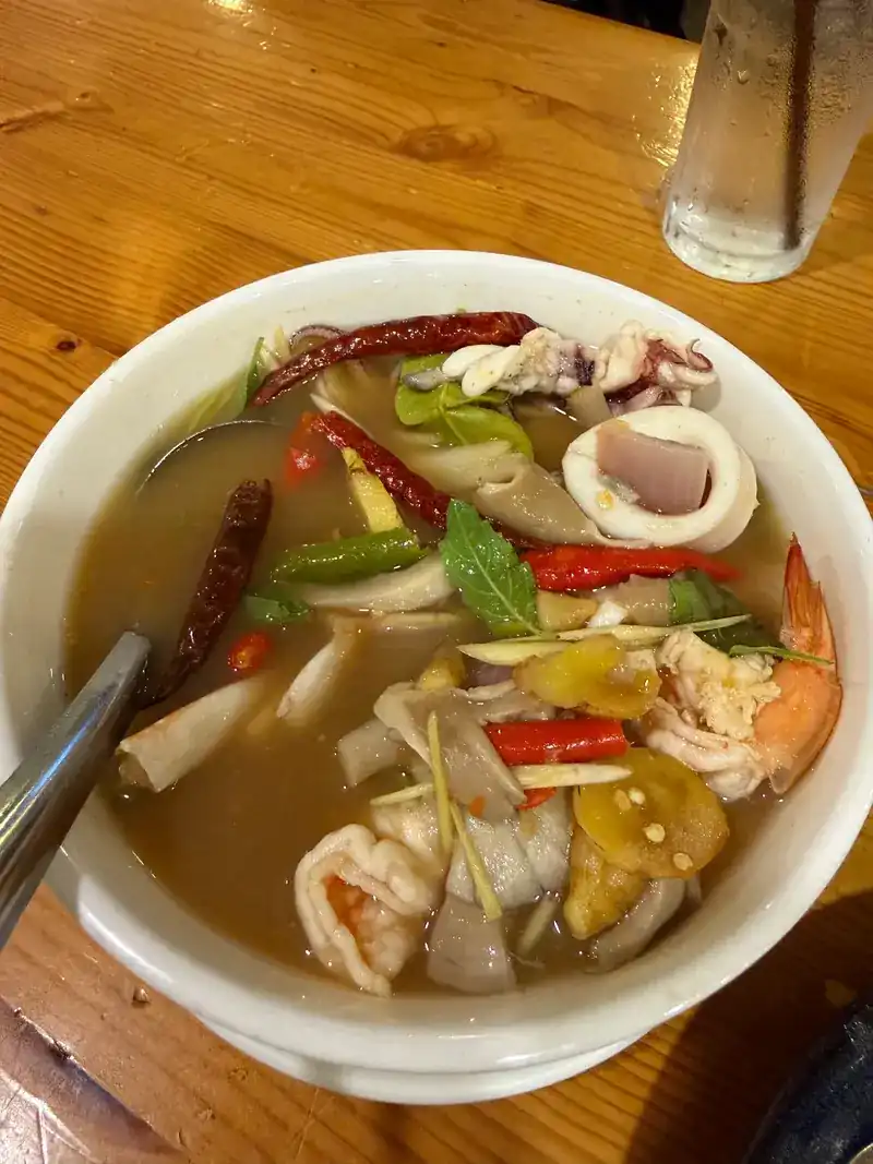 A bowl of seafood tom yum with prawns, squid and dried chillies