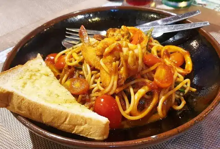 Seafood spaghetti in tomato sauce with garlic toast