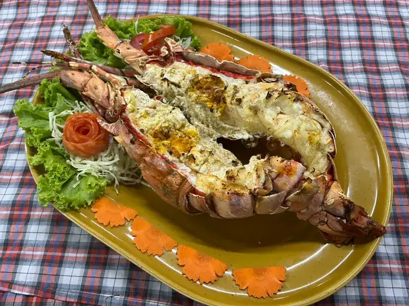 Grilled lobster split in half on a platter with carved carrot / ล็อบสเตอร์ย่างผ่าครึ่งบนจาน แต่งด้วยแครอทแกะสลัก