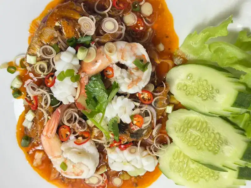 Spicy Thai salad with prawns, squid, lemongrass and chilli, cucumber on the side