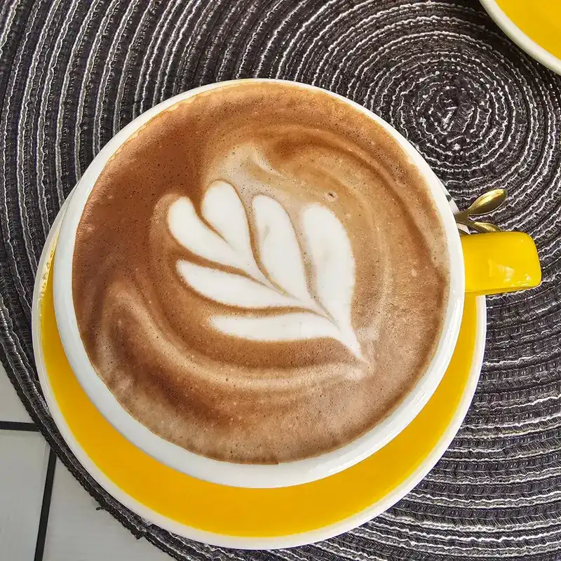 Latte art in a yellow cup