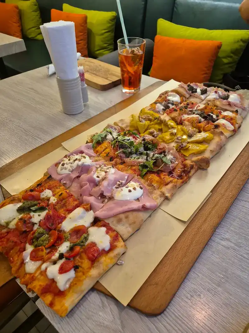A pizza almost a metre long with six different toppings on a wooden board