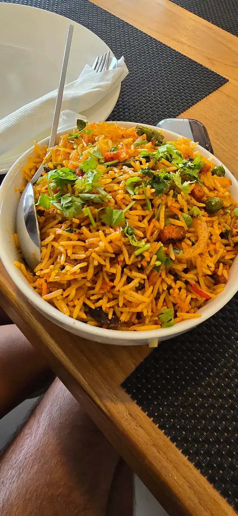 A bowl of biryani topped with fresh coriander