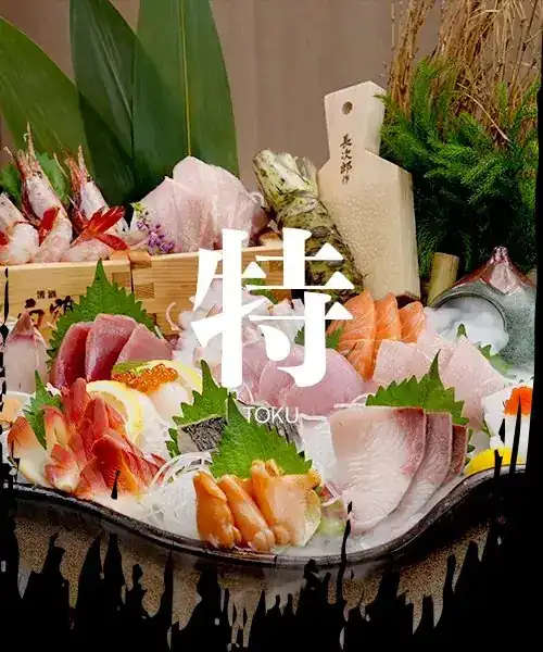 A sashimi platter dressed with bamboo leaves and shiso, titled with the character 特