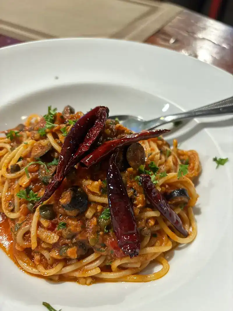 Spaghetti in tomato sauce with olives and dried chillies