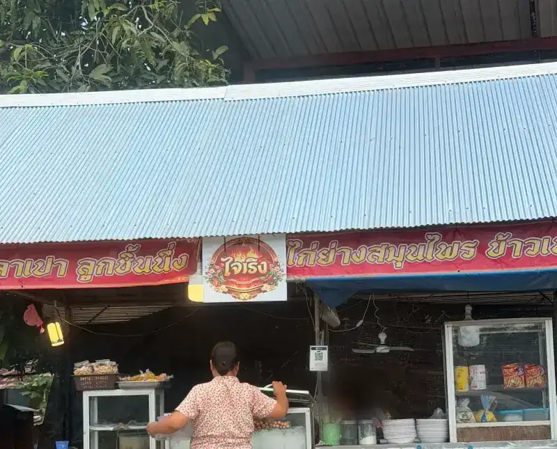 The stall under its tin roof, with the Jai Roeng sign