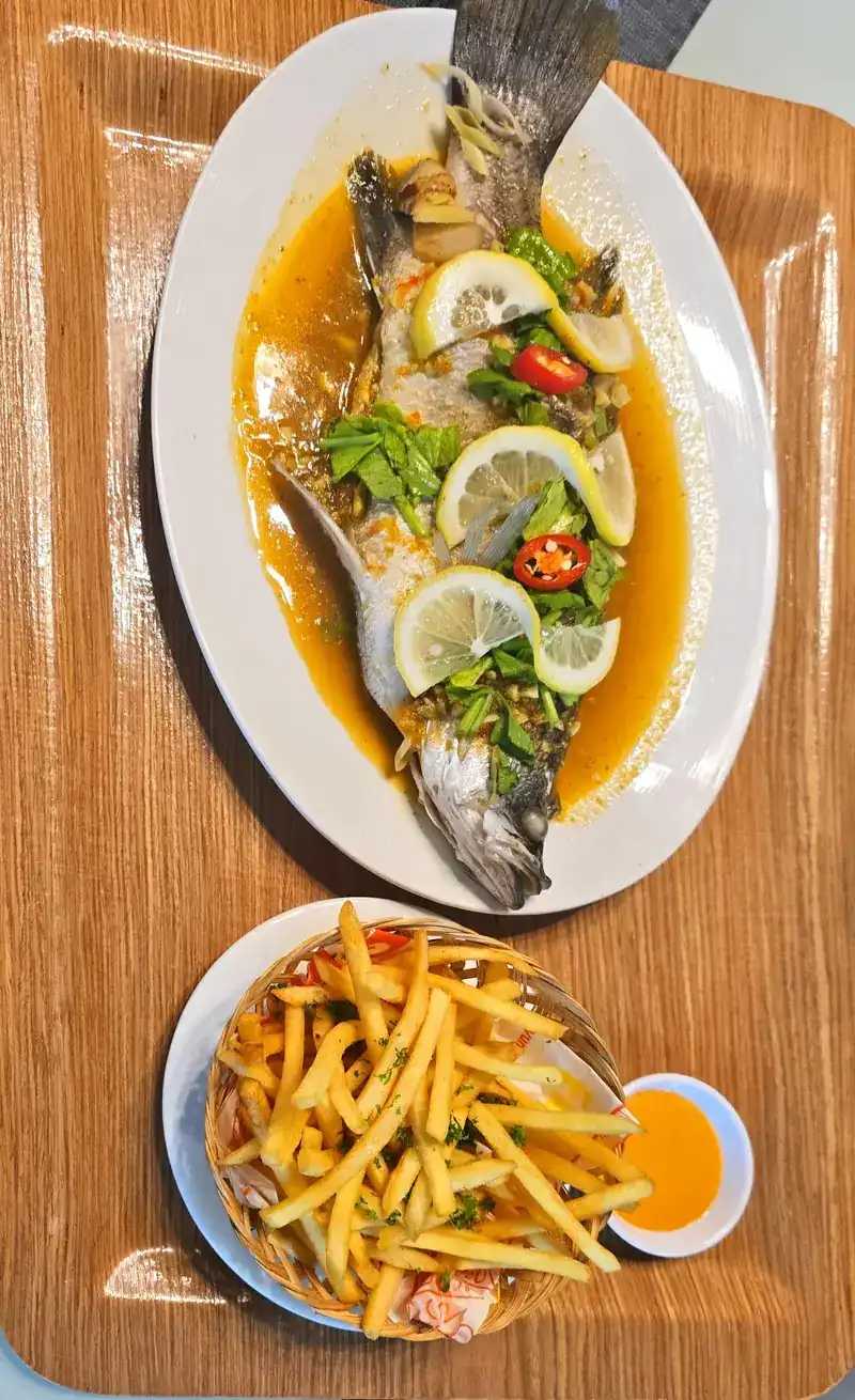 A whole fish with lime, chilli and herbs, with a bowl of fries