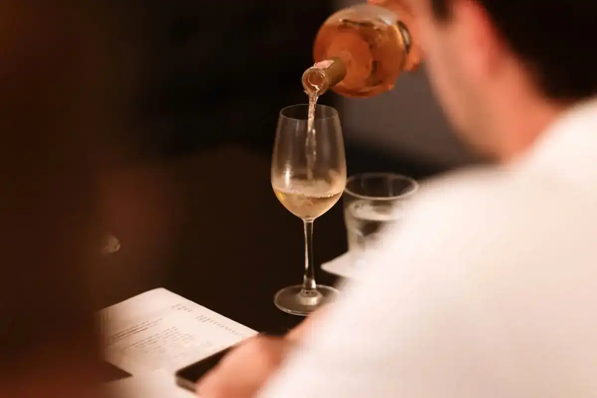 Wine poured into a glass at a candlelit table