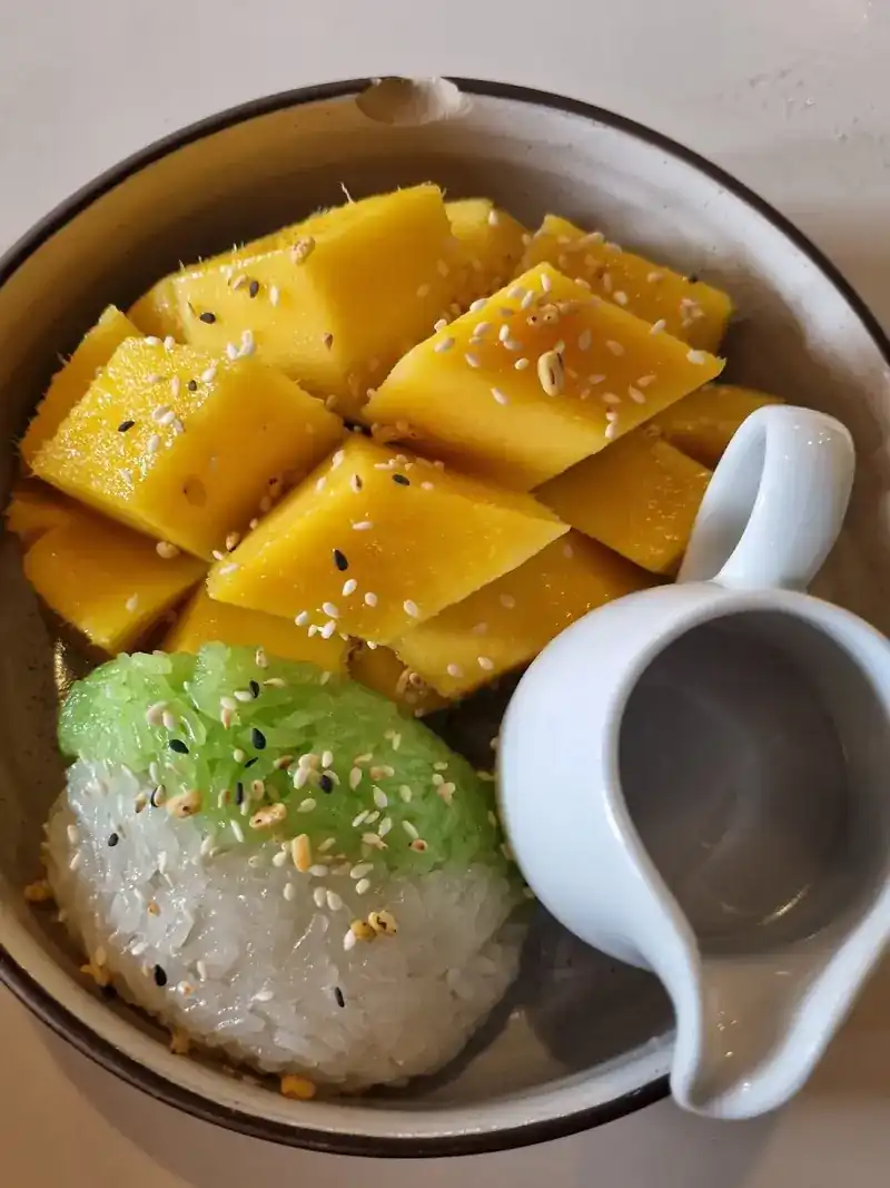 Mango with sticky rice, sesame and a small jug of coconut milk