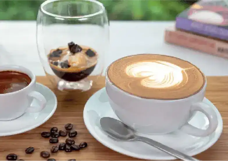 An espresso and a cappuccino with latte art on a wooden table