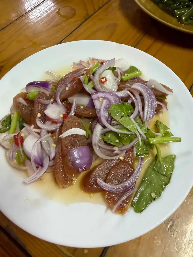 Chinese sausage salad with sliced red onion, chilli and greens