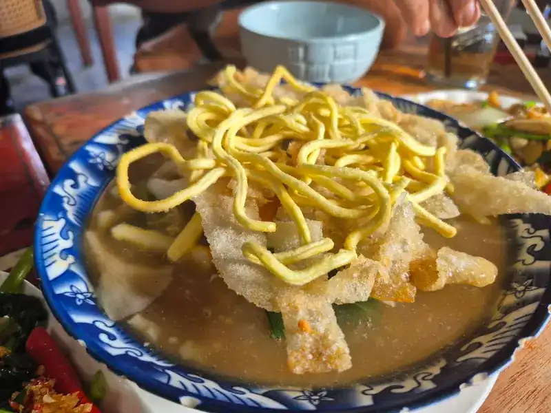 Noodles in broth, topped with crispy fried noodles