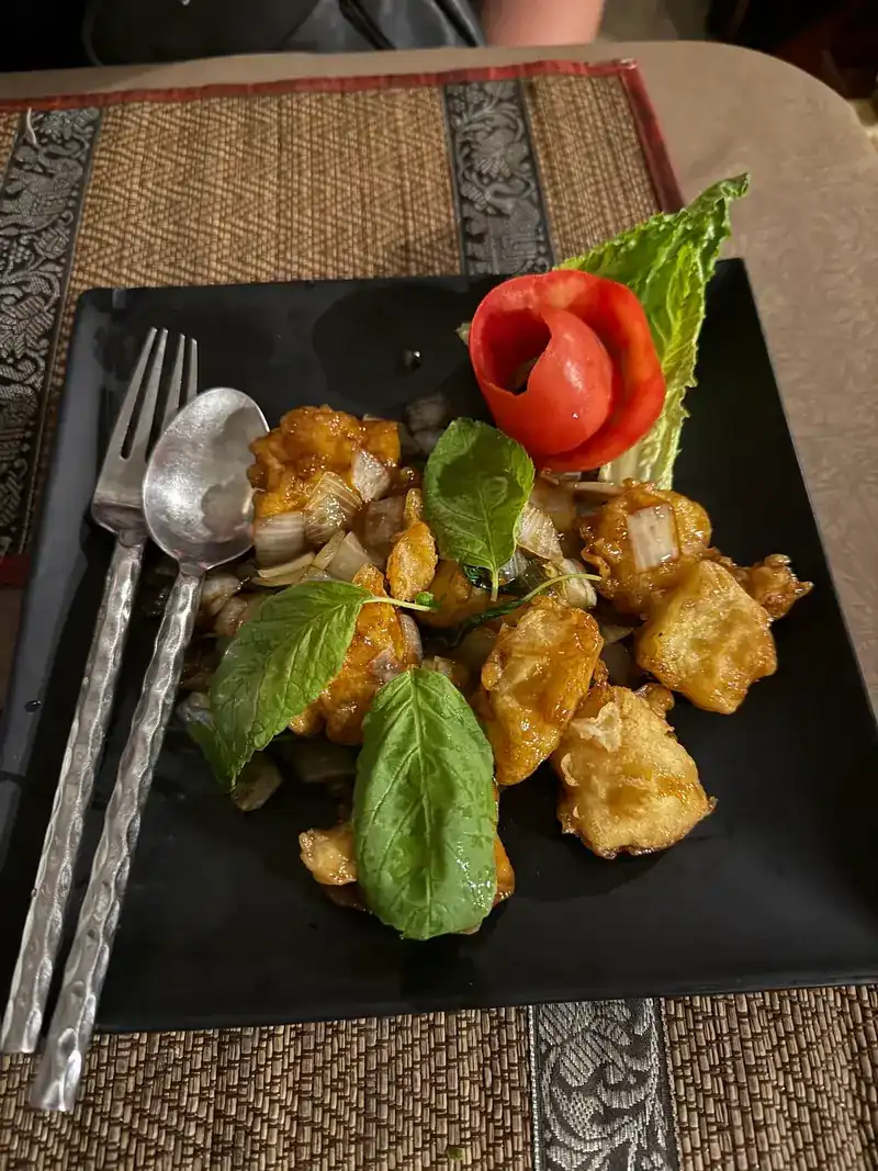 Crisp fried pieces with Thai basil leaves and a tomato rose