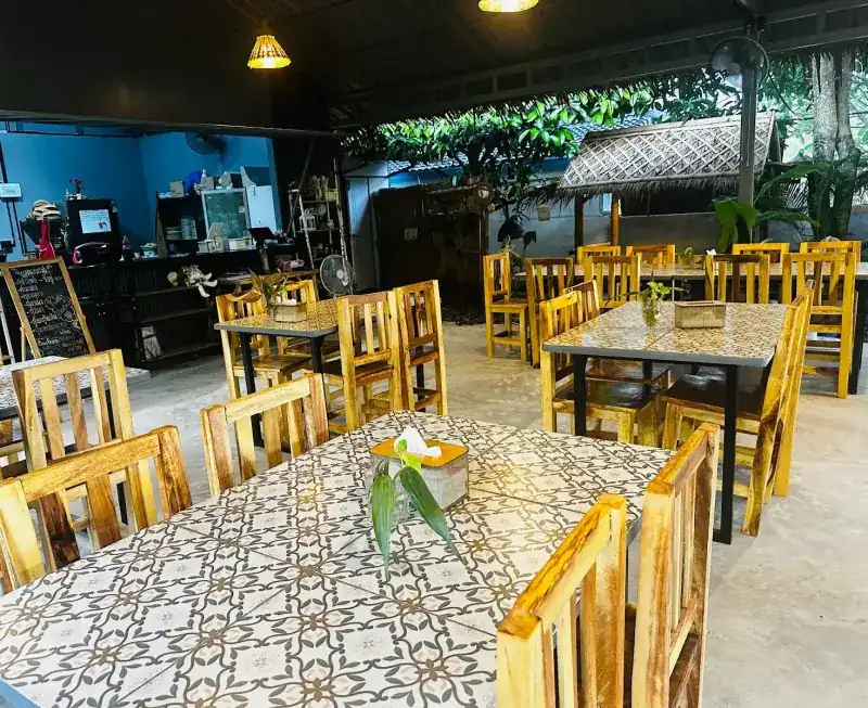 Tile-top tables and wooden chairs beside the counter