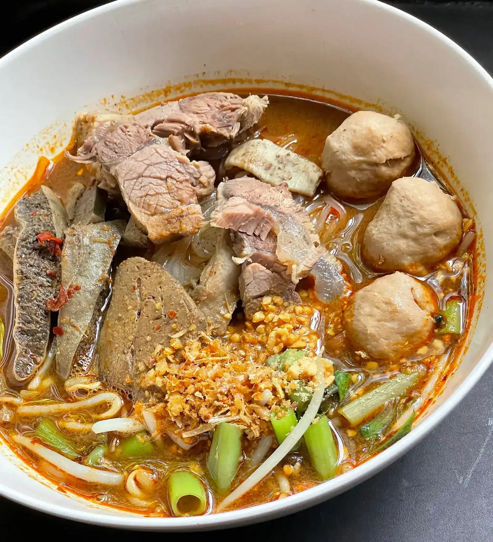 Beef boat noodles with meatballs, crispy garlic and morning glory — ก๋วยเตี๋ยวเรือเนื้อ ใส่ลูกชิ้น กระเทียมเจียว และผักบุ้ง