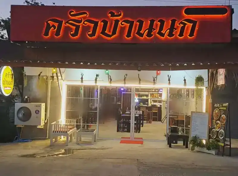 The restaurant at dusk, its red sign lit above the glass front