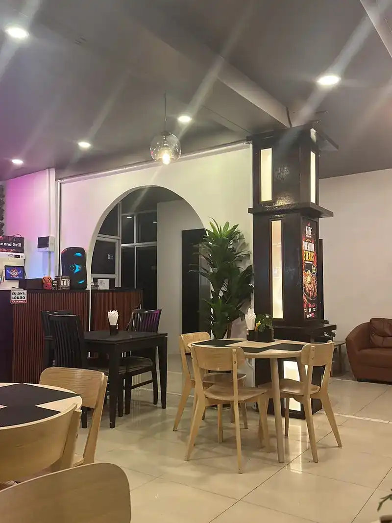Inside: wooden tables and chairs, an arched doorway and a lit wooden pillar