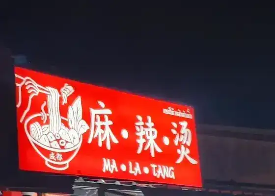 The shop's red lightbox sign at night, reading 麻·辣·烫 MA LA TANG