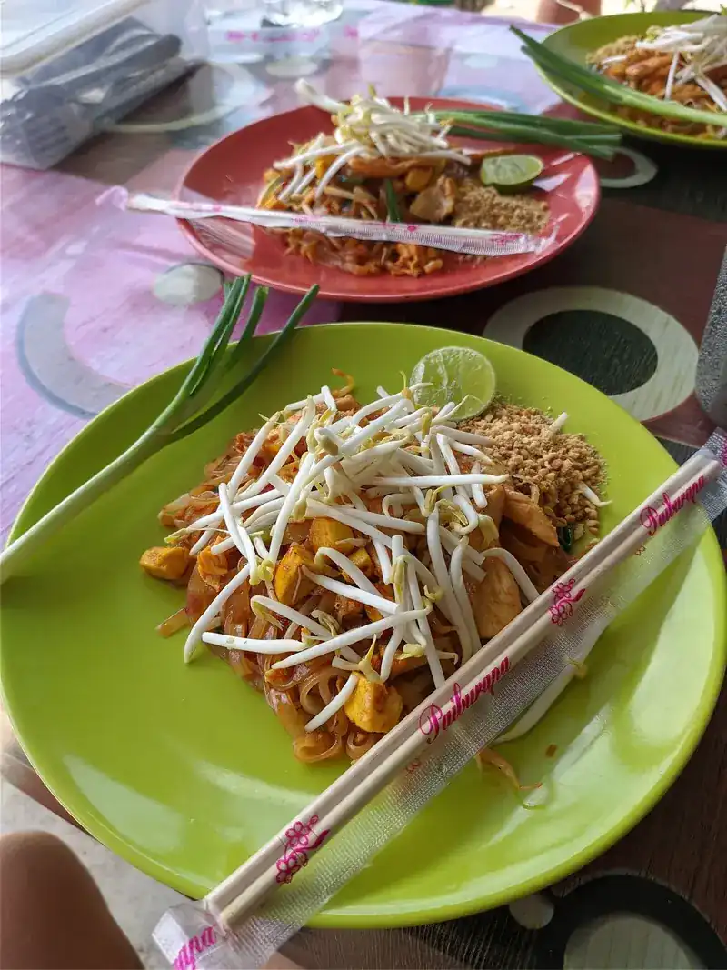 Pad thai with tofu, lime and crushed peanuts on a lime-green plate