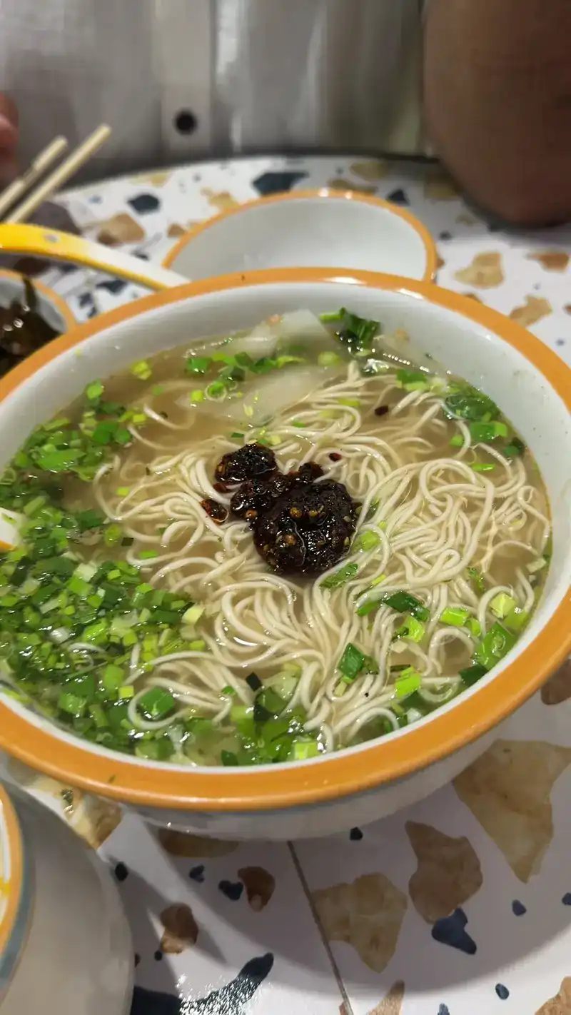 Thin noodles in clear broth topped with spring onion